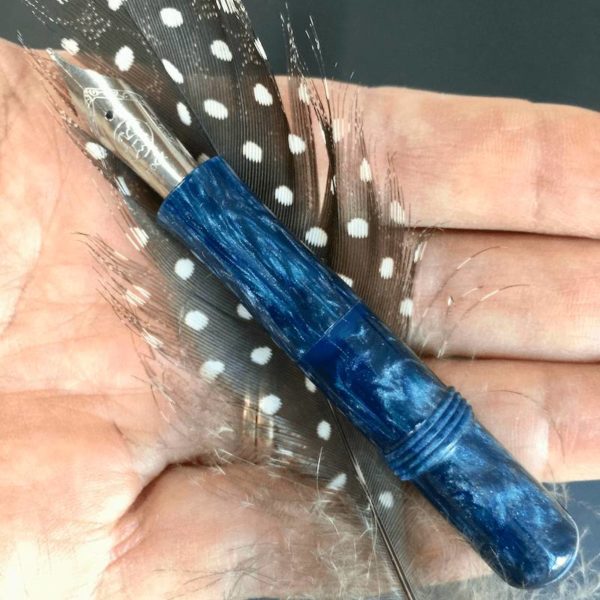 Streaked teal pocket pen shown against a hand