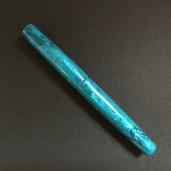 Turquoise Tuesday fountain pen against a dark background