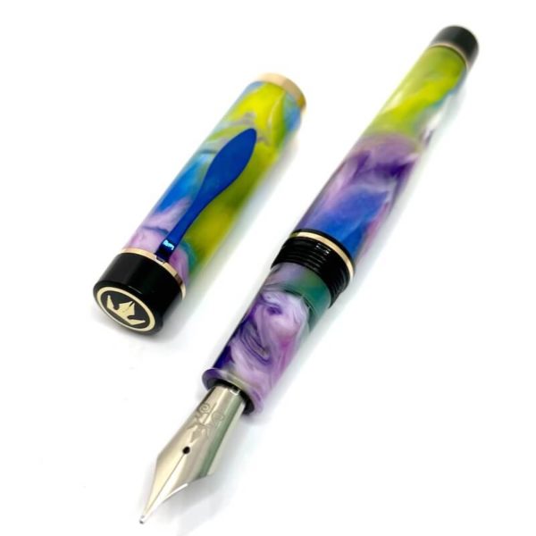 A pen made from yellow pink purple and blue resin with a blue clip