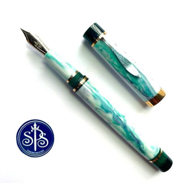 Uncapped fountain pen showing a body in pale green with swirls of darker green and violet