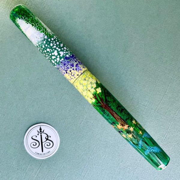 A fountain pen painted with abstract flowers as if looking into the distance