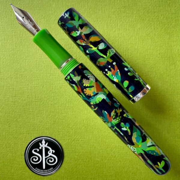 Uncapped fountain pen with a Prussian blue background and brightly coloured patterns of birds and lush foliage.