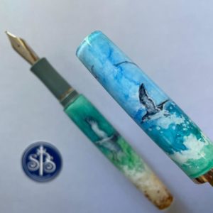 Fountain pen cap with a gull skimming across the top of a breaking wave
